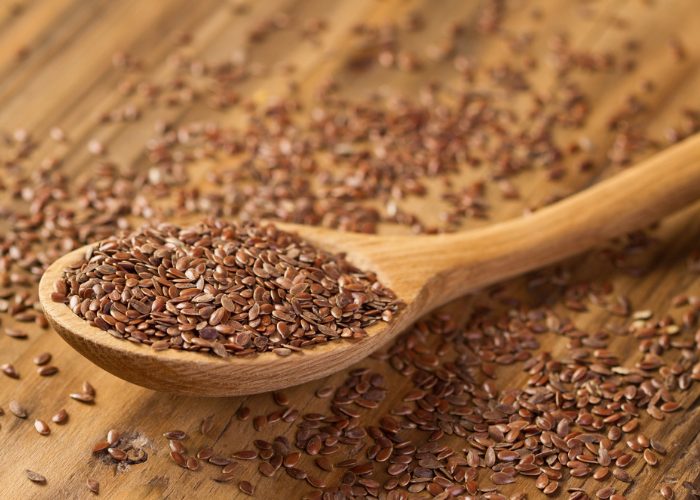 A wooden spoon full of flax seeds