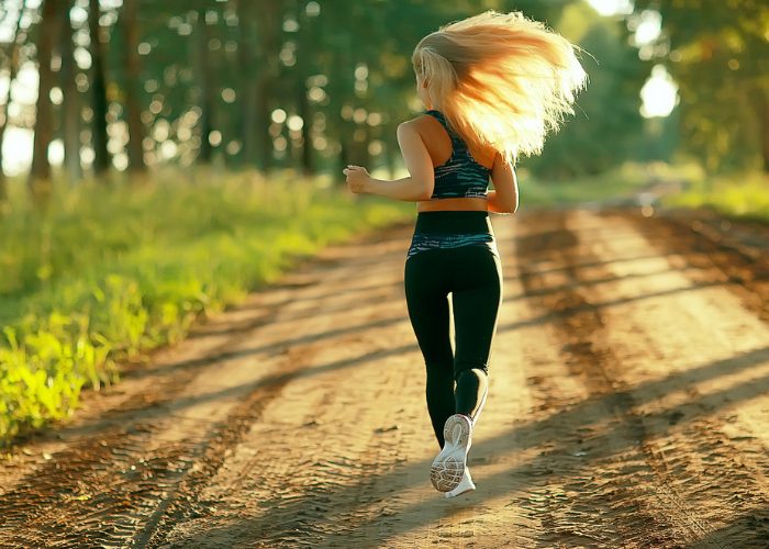 Blonde woman running on a forest path outdoors
