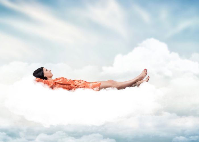 Woman lying on clouds in a dream