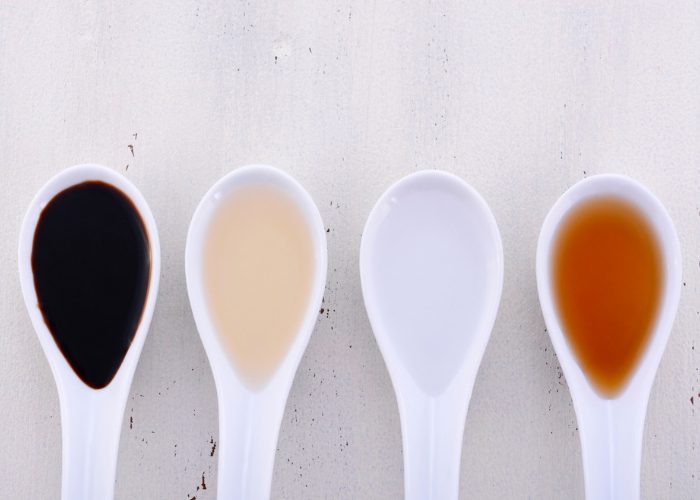 Four soup spoons holding different vinegars