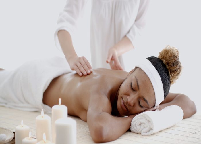 Woman getting a massage with aromatherapy oils and candles