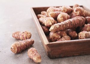 A pile of Jerusalem artichokes in a wooden container