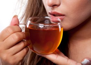 A woman drinking a cup of teatox
