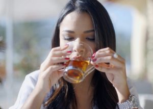 Woman sipping teaxtox from a cup