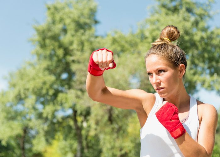 Blonde woman outdoors practicing kickboxing hooks