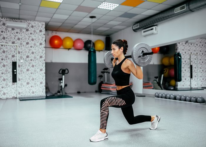 Woman in the middle of a barbell lunge