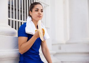 Woman eating a banana as a pre-workout