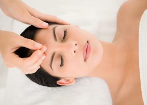 Woman getting acupuncture treatment in her forehead