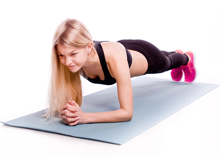 Woman in plank position on a yoga mat