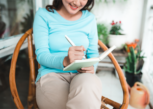 Woman sitting in her terrace journaling