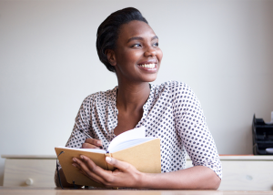 African american woman smiling with an open journal book