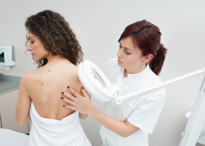 Woman getting her back moles examined by a doctor.