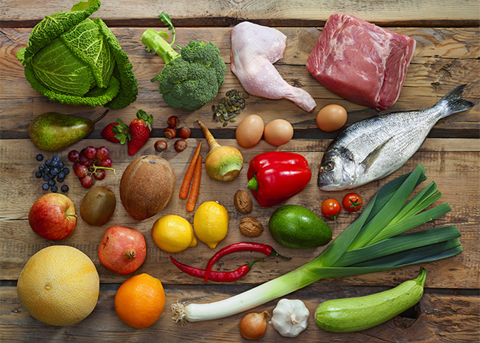 Flat lay of pegan (paleo-vegan) diet foods such as vegetables, fruits, fish, lean eat proteins