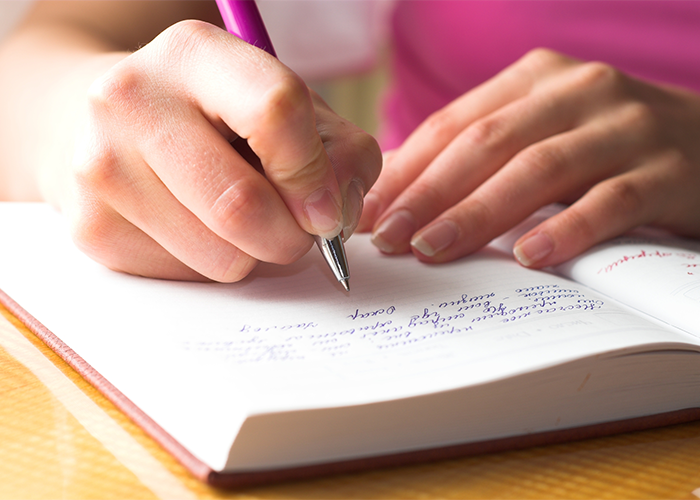 Close up of woman journaling and writing in her journal