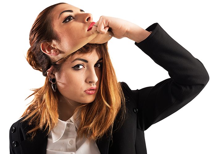 Woman suffering from imposter syndrome removing a mask of another woman's face to reveal her true self