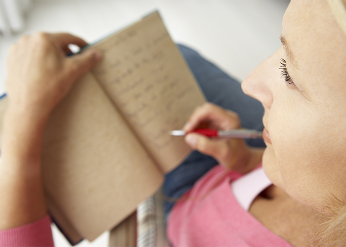 Blonde woman in pink shirt journaling