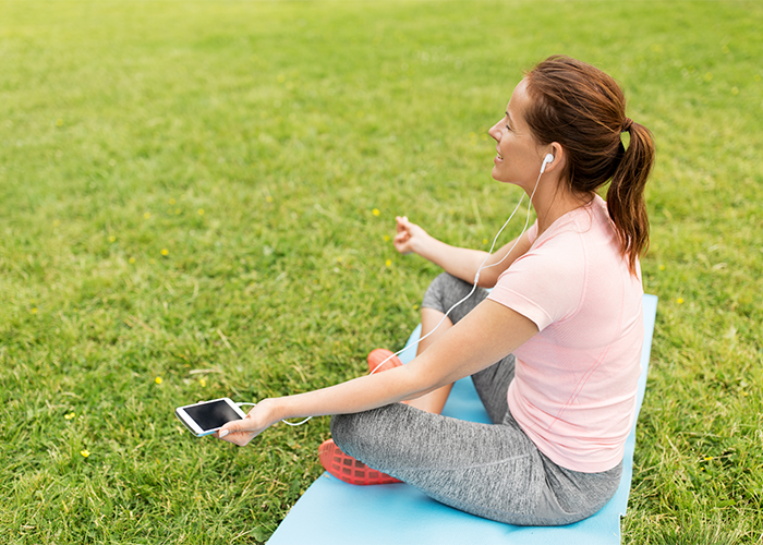woman doing yoga outdoors with yoga app