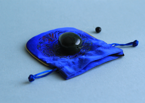 Black yoni egg on blue satin pouch
