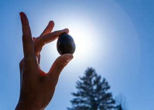 Woman holding up a yoni egg to the sun