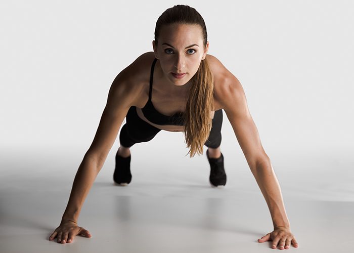 Woman doing wide arm pushups as part of her chest and tricep workout