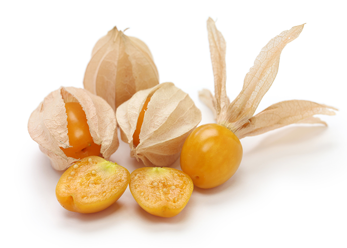 Close up of some golden berries in husks, an open berry, and a halved golden berry on a white surface.