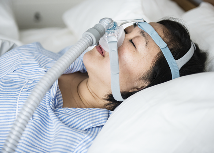 Woman sleeping with a CPAP anti snoring device.