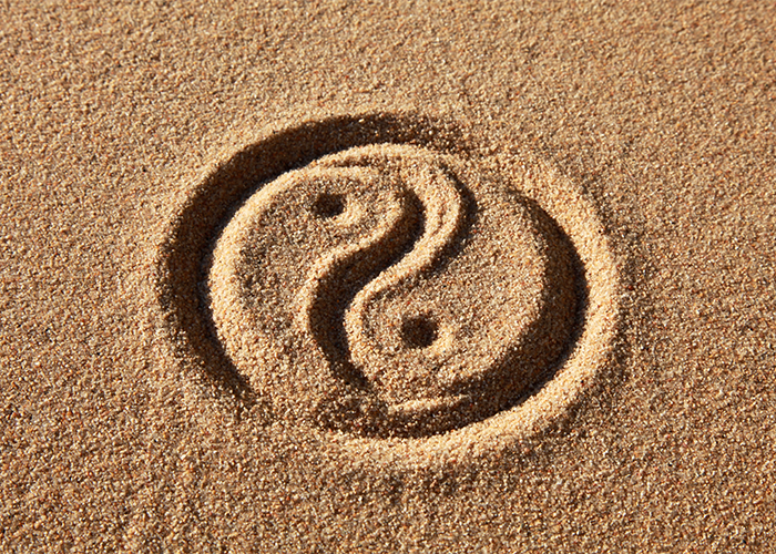 Yin yang symbol drawn in sand