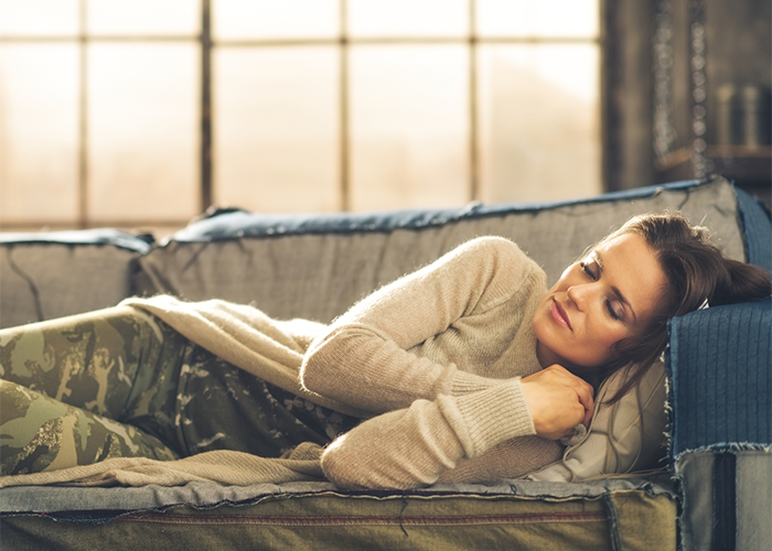 Young woman napping on her couch during the day