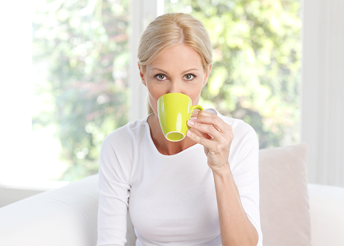 Blonde woman drinking a cup of jasmine tea