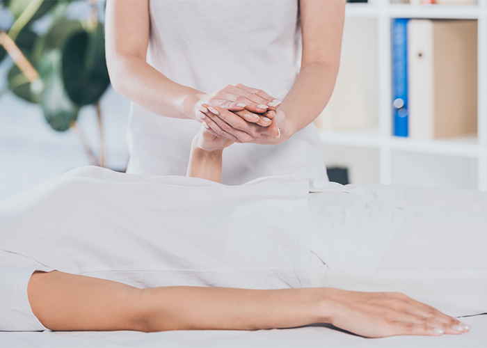 Reiki practitioner holding a patient's hand to perform reiki healing