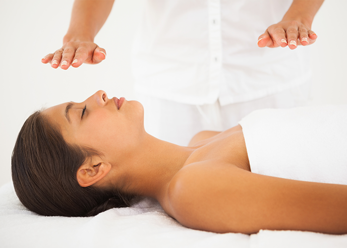 Woman lying on a massage table during a reiki healing session