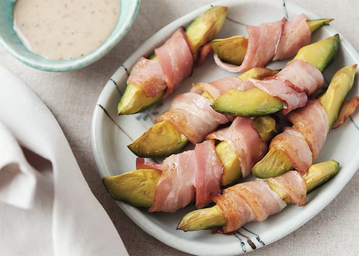 Ketogenic bacon wrapped avocado pieces on a plate