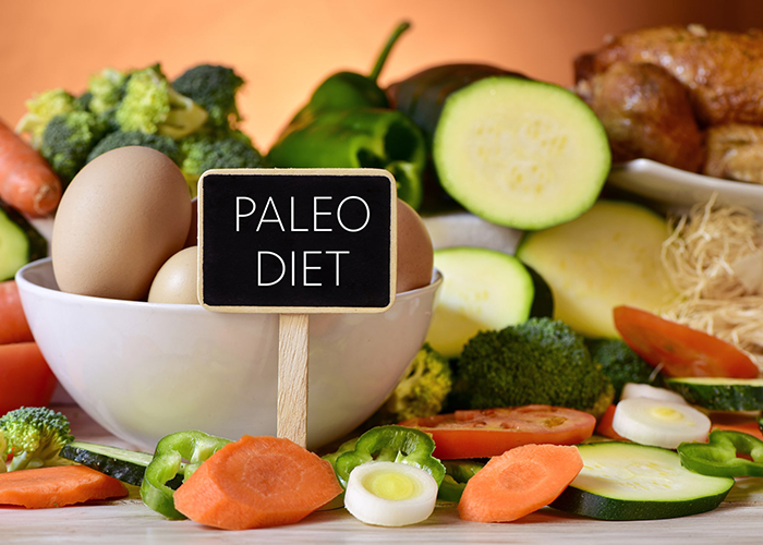 Sign that says, "Paleo Diet" with a background of paleo-approved foods including boiled eggs, carrots, broccoli, and zucchini
