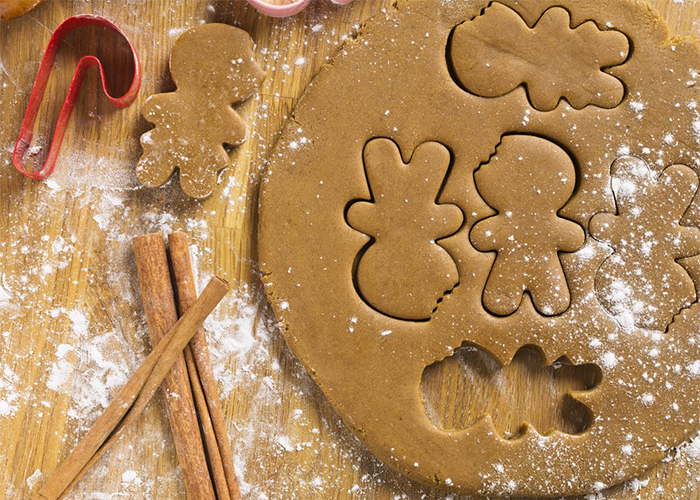 Paleo gingerbread cookie dough being made into in Christmas shapes with cookie cutters