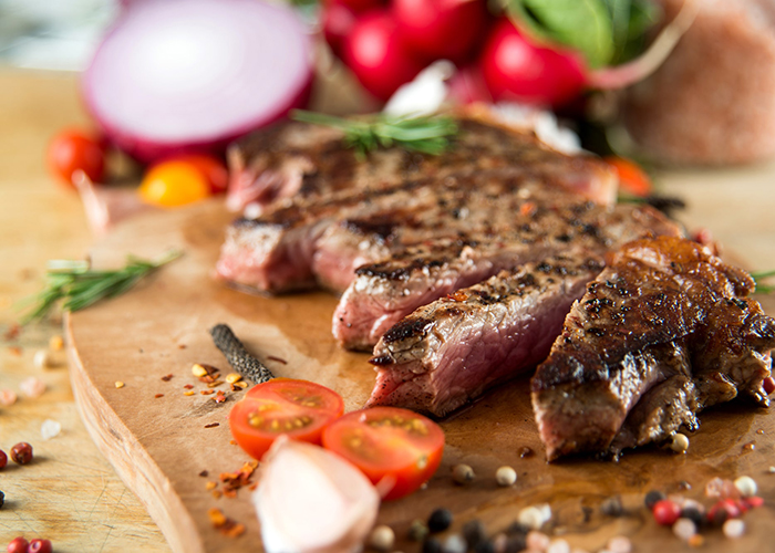 Juicy paleo steak resting on a wooden cutting board