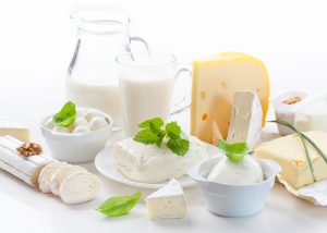 A spread of dairy foods and drinks including cheese, ice cream, butter, and milk