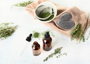 Thyme essential oil bottles surrounded by fresh thyme