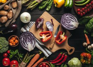 A top-down view of a spread of vegetables on a chopping board and table