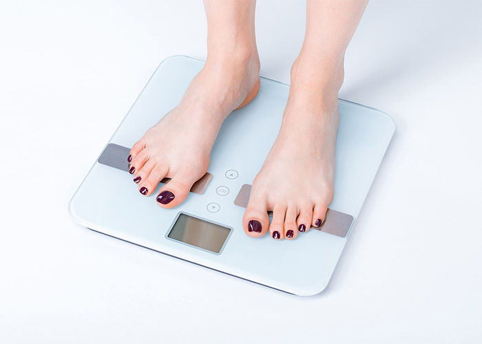 Woman standing on a bathroom scale