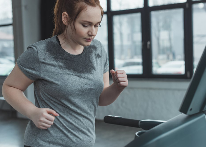 woman running on a treadmill to overcome keto weight loss plateau