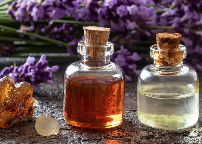 Two large bottles of De-stress essential oil blend with myrrh, lavender, and frankincense oils