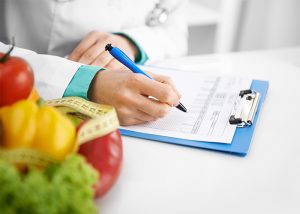 A dietician writing her recommendations for a treatment plan for a patient