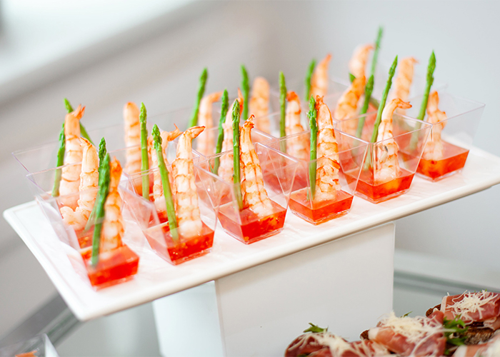 A plate of high-end Keto shrimp appetizers dipped in sweet and sour with a sprig of asparagus 