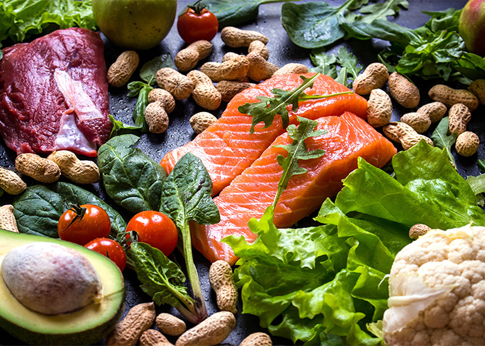An assortment of different Paleo foods including fish, vegetables, nuts, and fruit