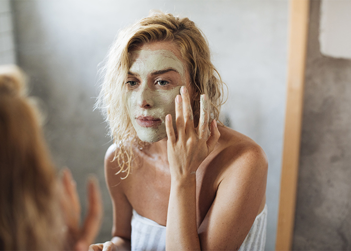 woman-applying-diy-acne-mask-on-her-face-in-bathroom