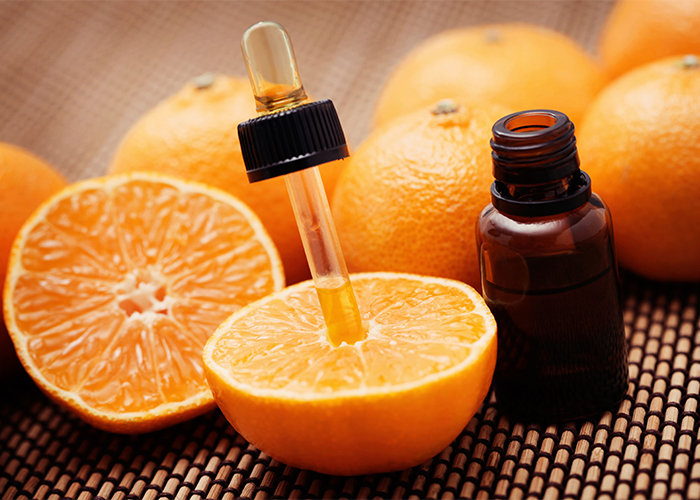 essential oil bottle with dropper inside an orange